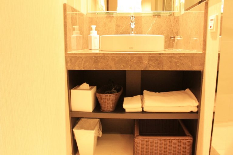 洗面台の下には、ティッシュ、ドライヤー、バスタオル、タオル、ゴミ箱、着替えを入れるカゴが収納されています