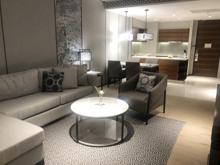 リビングルーム。テレビの前から見るソファとキッチン