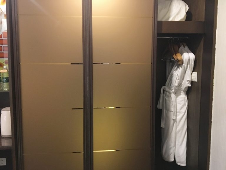 右側を開けた状態のクローゼット。バスローブが入ってインす