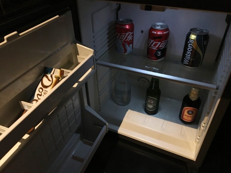 冷蔵庫内部。ミネラルウォーター、コーラ、ビール、炭酸水、チョコレートがあります。全て有料です