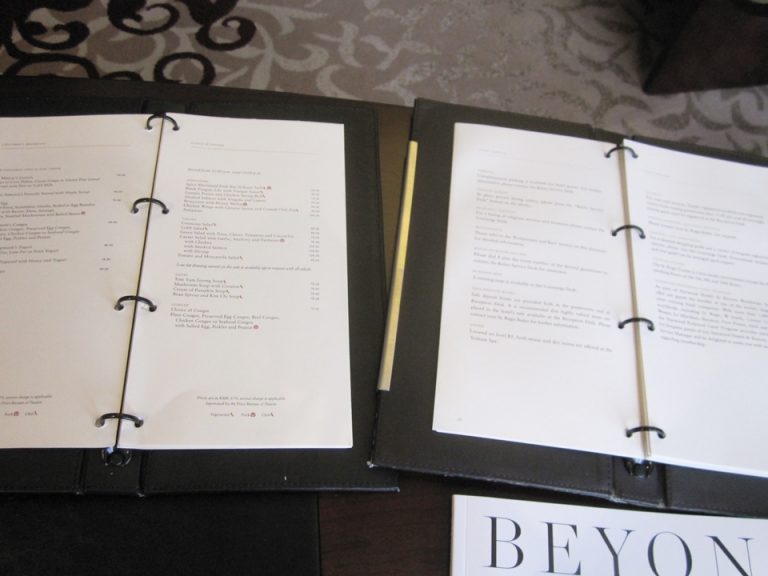 デスク上のホテル案内とルームサービスメニュー