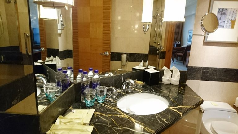 0705_客室のバス・トイレ-洗面台全体 (3)お水は毎日のサービス