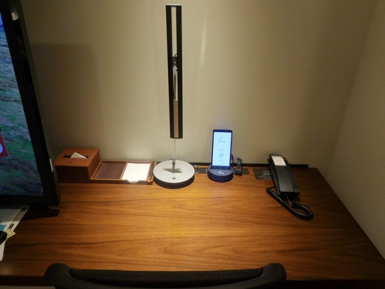 デスク 縦長いのがデスクライト、その横にはホテルや周辺の情報が見れるタブレットがありました