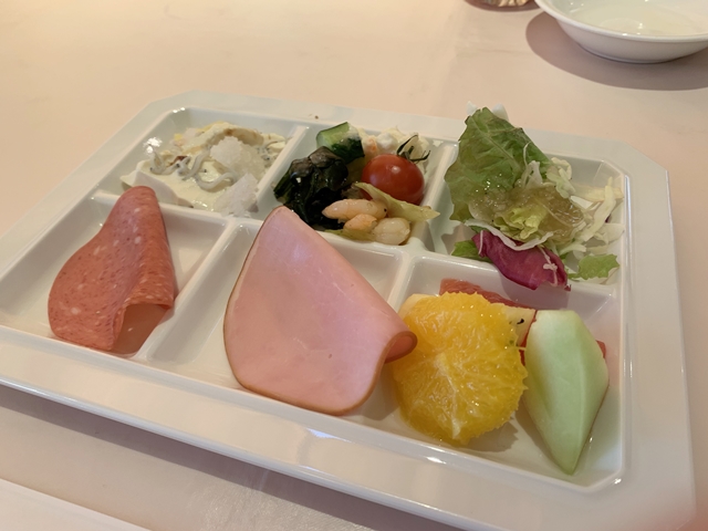 3皿目のプレートは、手作り豆腐、サラダはミニトマト、きゅうり、海藻サラダ、小海老のマリネ、グリーンサラダに玉ねぎドレッシング、サラミ、ハム、フルーツはオレンジ、メロン、グレープフルーツ、パイナップルです。