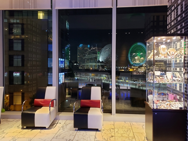ホテルフロントからみなとみらいの景色とランドマークタワーへと繋がる2階の歩道橋が見えます
