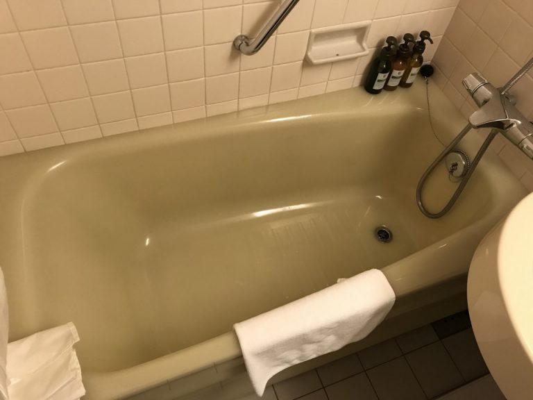 バスタブ。白い床マットがある