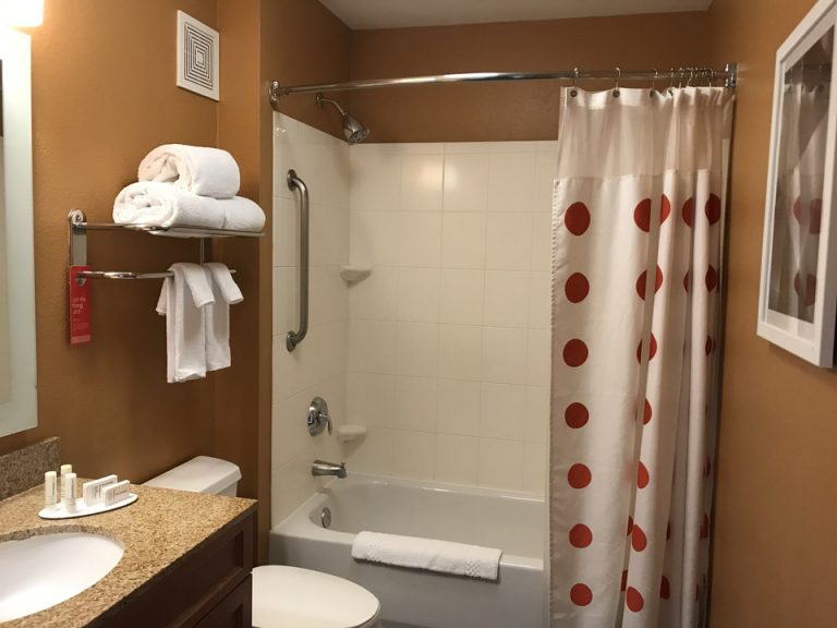 可愛らしいカーテンがかかるバスルーム