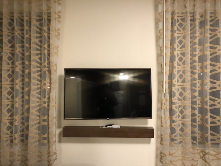 ベッドの隣の窓と窓の間にテレビがあります