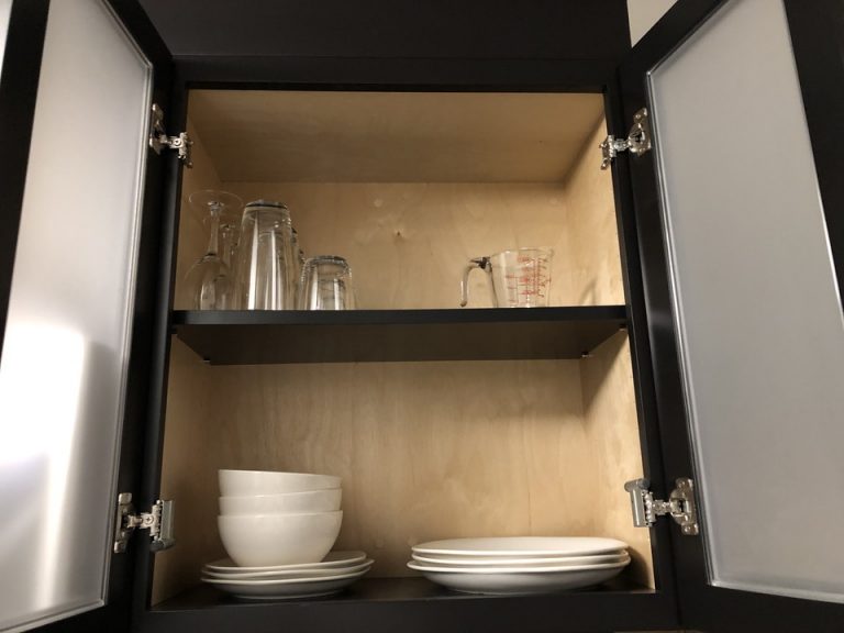 キッチンの上の食器棚にはコップやお皿がたくさん