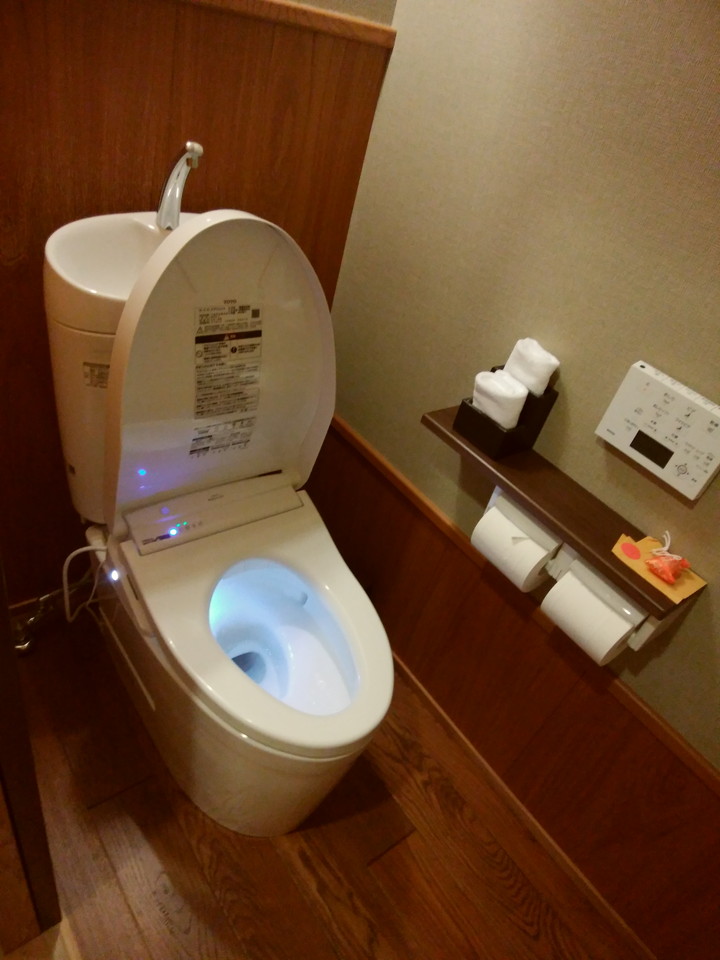 1畳ほどの広さ控え目のトイレ。蓋は自動開閉式