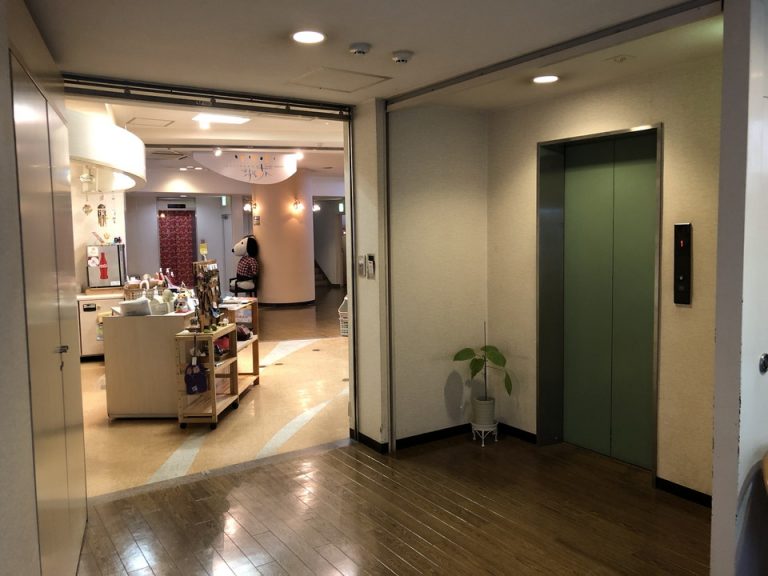 手前緑色が露天風呂付客室に行くエレベーター 売店向こう側に客室用ピンク色エレベーター