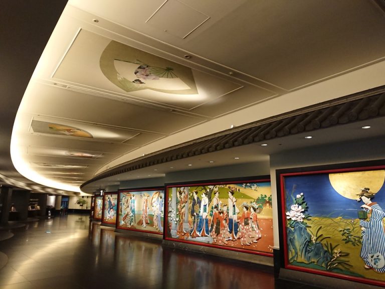 エントランス内観 壁には彩色木彫板、天井には日本画が飾られ、訪れる人の目を愉しませてくれます。しばらく進むと招きの大門があります。