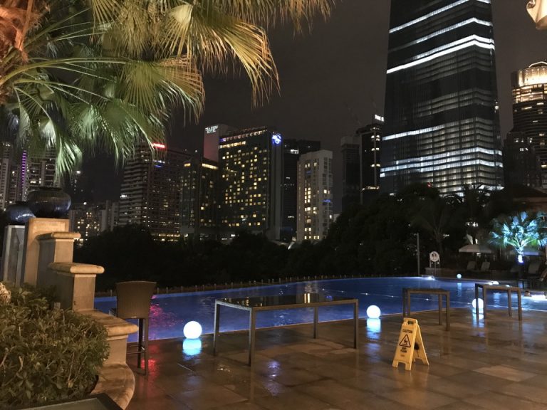 夜のプールサイドです。雨天ですが、入っている人が数人いました。
