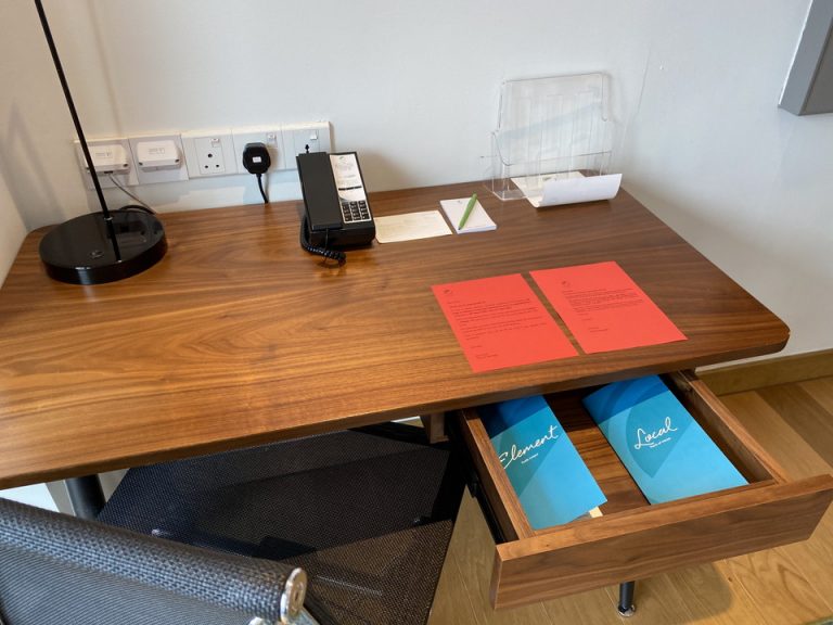 窓辺に位置するデスクです。文房具はメモ帳とボールペンのみでした。