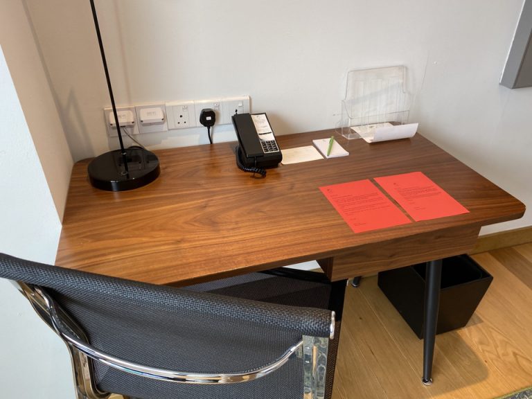 窓辺に位置するデスクです。文房具はメモ帳とボールペンのみでした。(1)