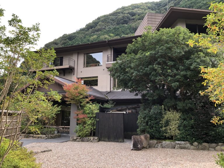 ②【外観】本館の建物外観になります。周辺に小さな造園スペースがあり、右手側に足湯があります