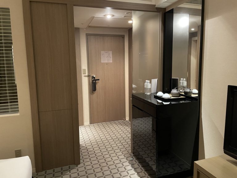 ベッド側から見たドア・食器類・冷蔵庫