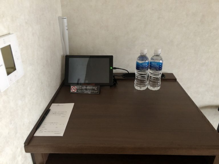 冷蔵庫の上には無料の水とフロント連絡用のタブレット