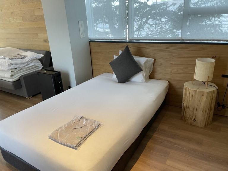 入り口右側のバスルームから見たベッド