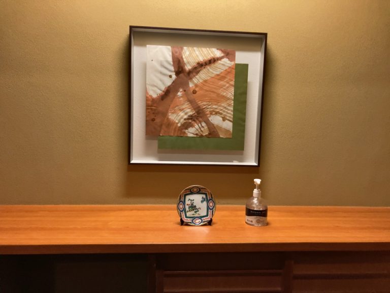 下駄箱上の消毒液と工芸品