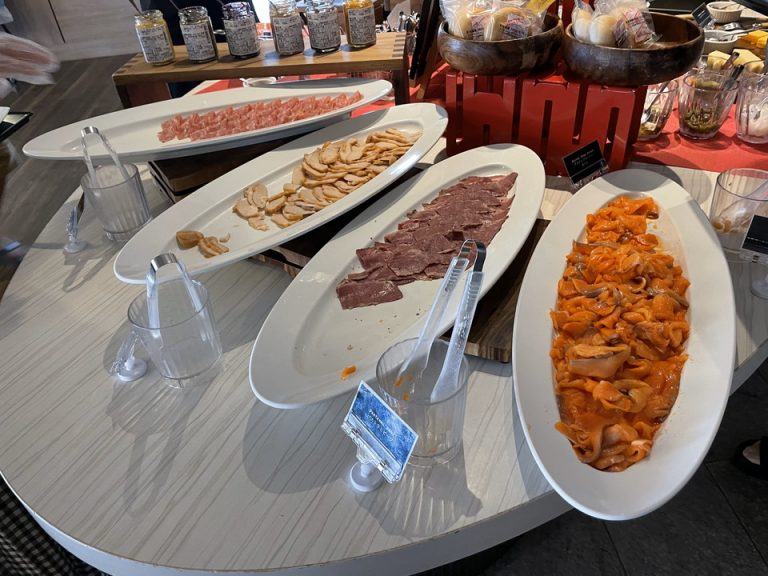 パンの周りにあるスモークサーモン、ベーコン類